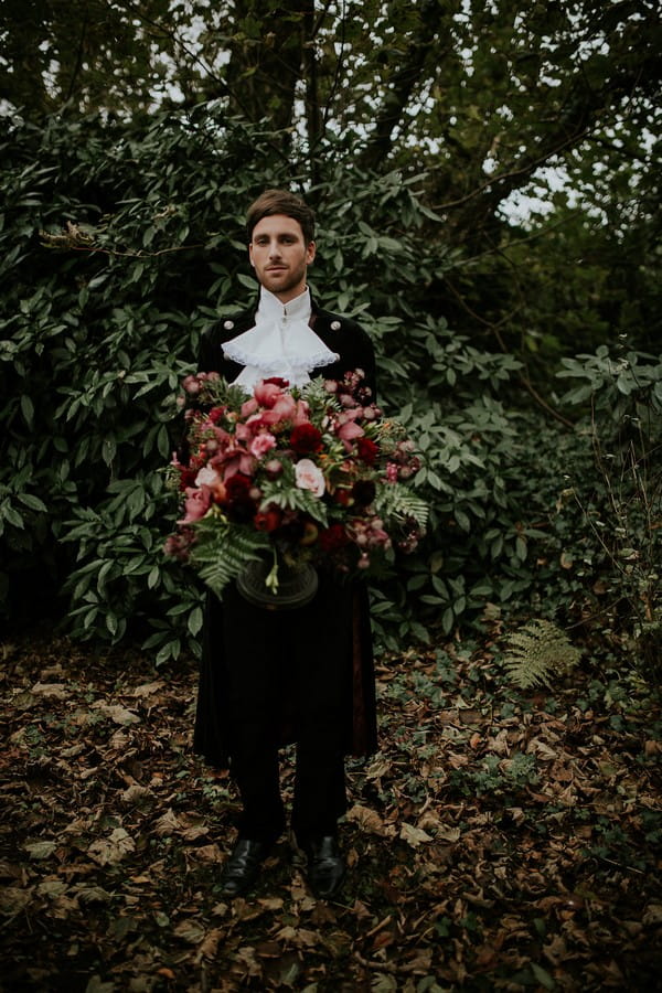 Groom in Poldark clothing holding large bouquet