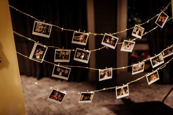 Photo booth pictures pegged to fairy lights