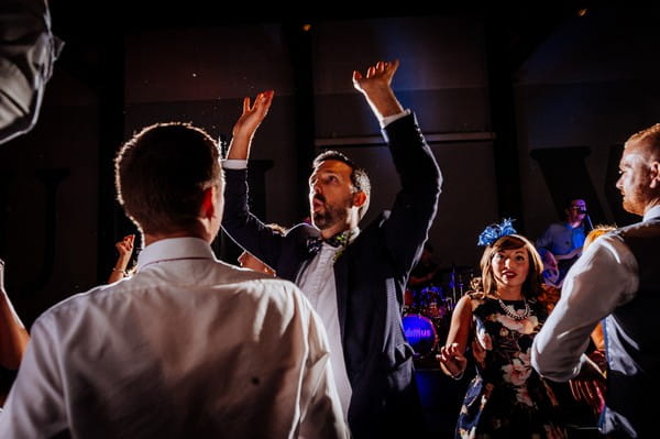 Wedding guests with arms in the air