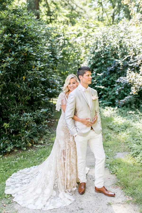 Bride hugging groom from behind