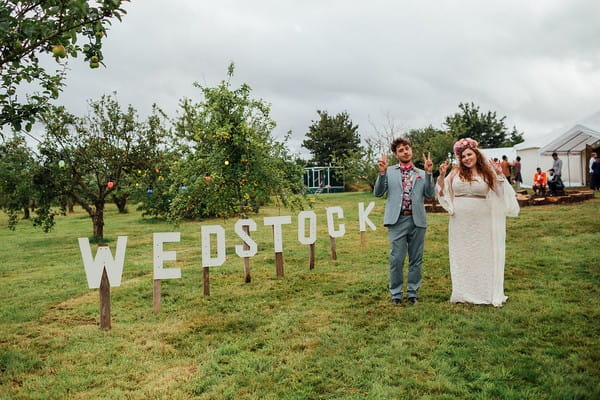 Bride and groom standing next to Wedstock sign