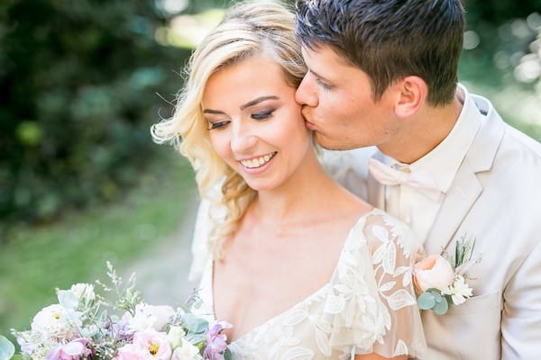 Groom kissing bride on the cheek