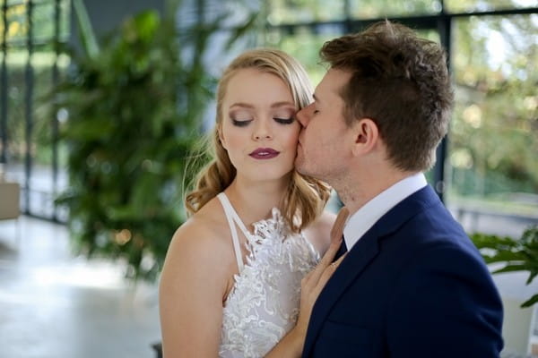 Groom kissing bride on the cheek