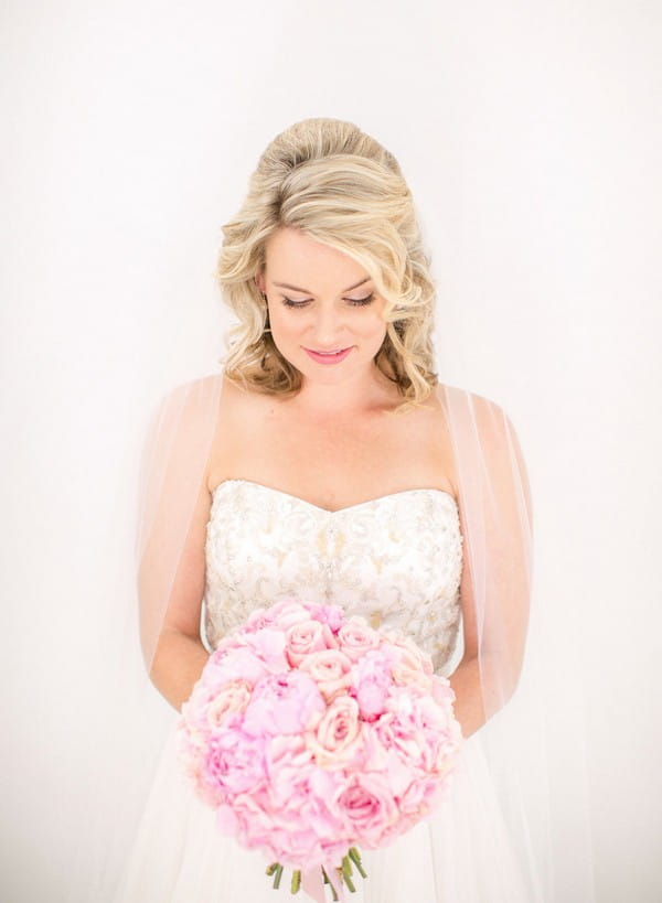 Bride looking down at pink bouquet