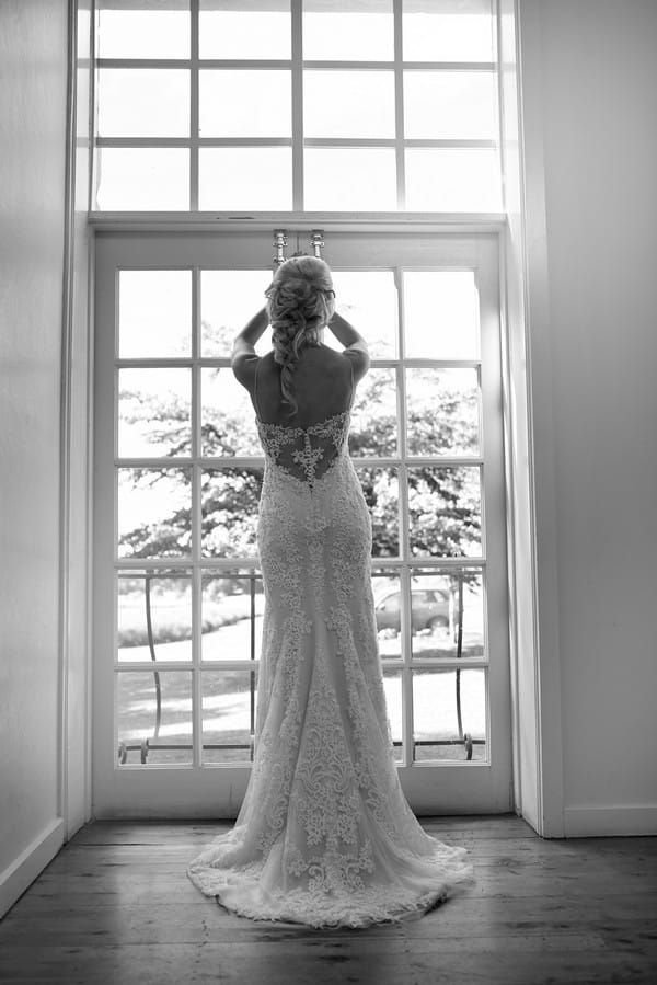 Bride standing looking out of window