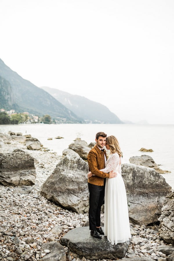 Bride and groom by rocks at Lake Como