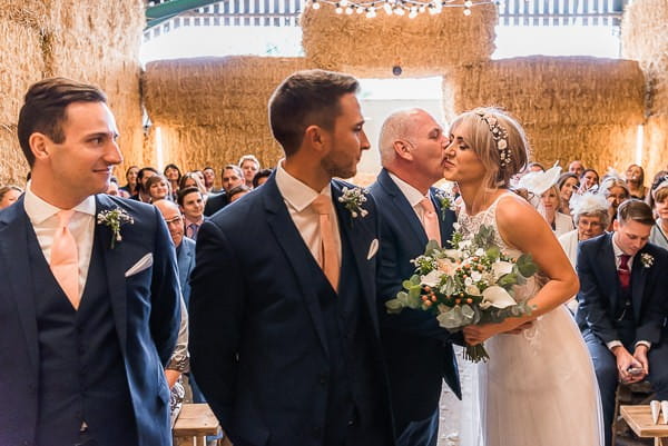 Father kissing bride at altar