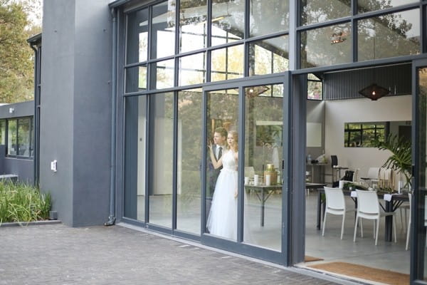 Bride and groom at window of The Conservatory Franschhoek