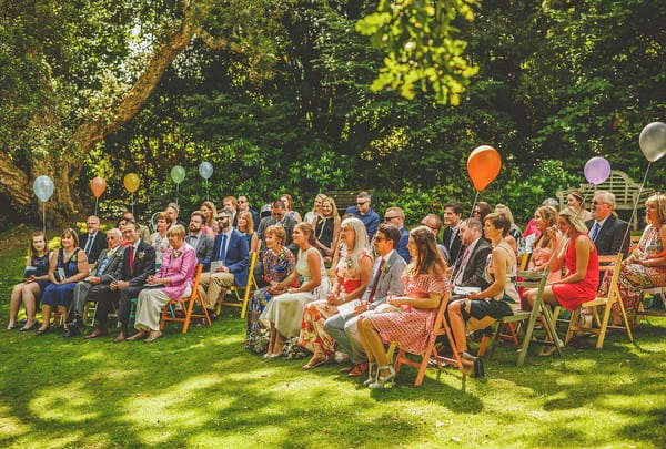 Wedding guests sitting outside for ceremony at Colehayes Park