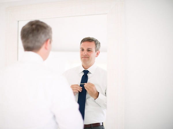 Groom doing up tie