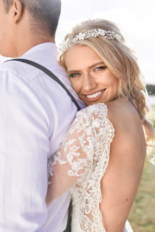 Bride with open back dress hugging groom from behind