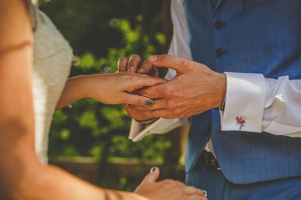 Groom putting ring on bride's finger