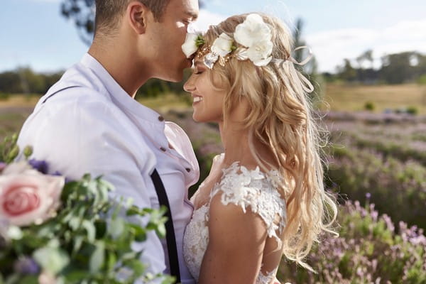 Groom kissing boho bride on head