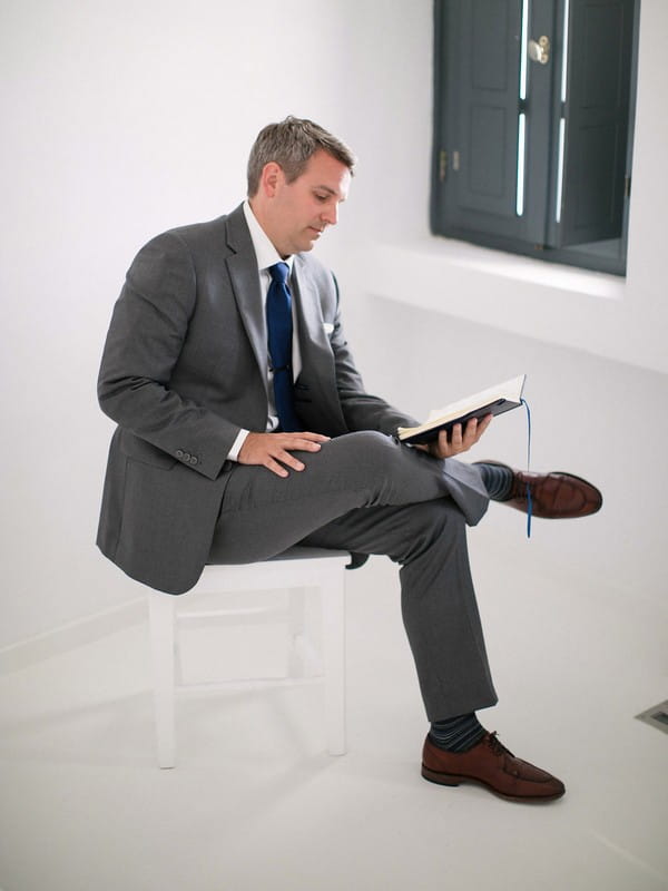 Groom sitting reading wedding vows