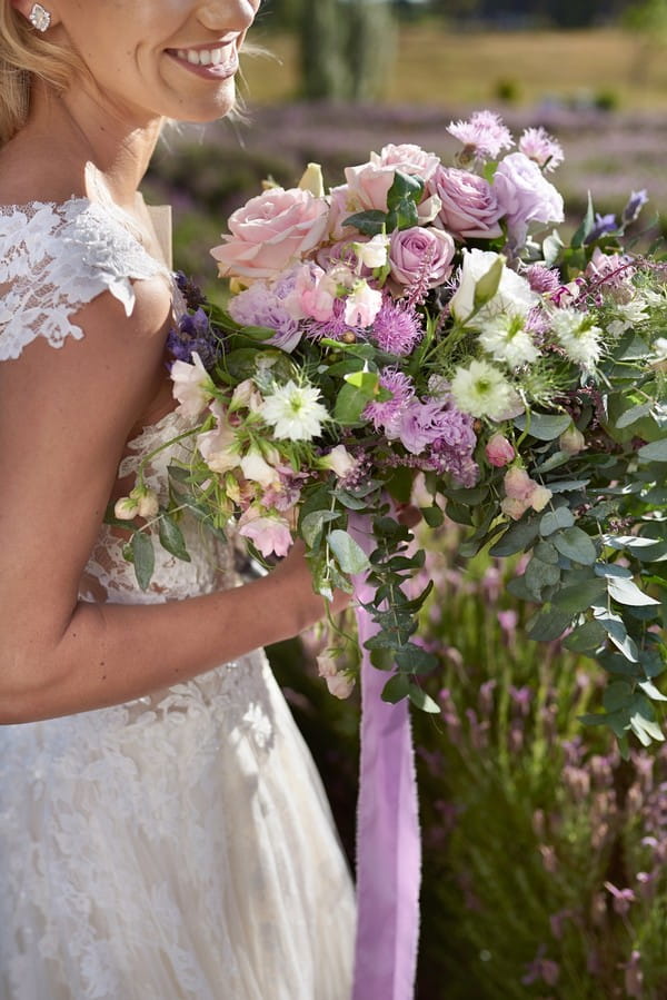 Bride holding lilac and lavender bouquet