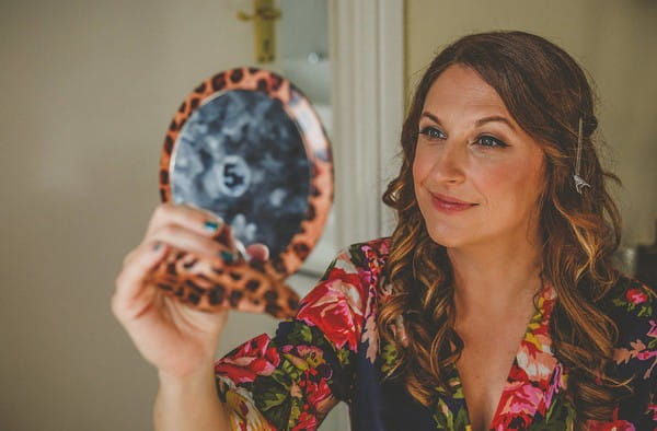 Bride looking at wedding make-up in mirror