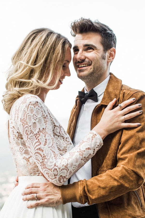 Bride with lace detailed wedding dress with groom