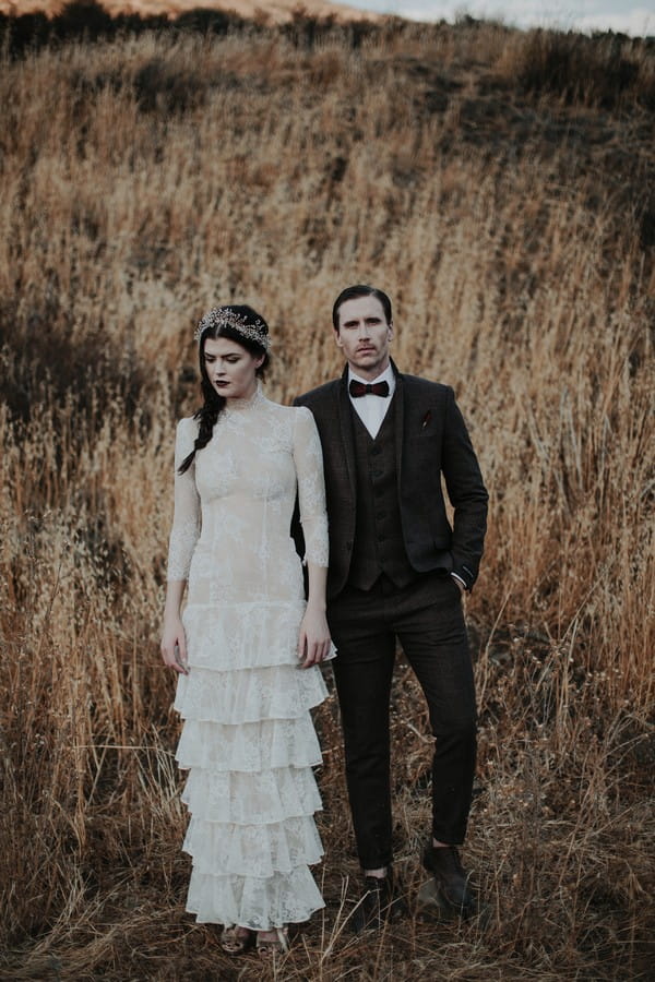 Bride and groom standing by long grass