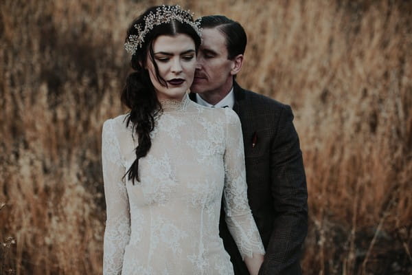 Groom standing behind bride