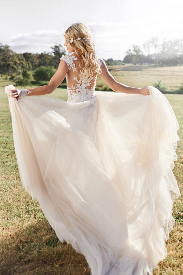 Boho bride holding out skirt on wedding dress