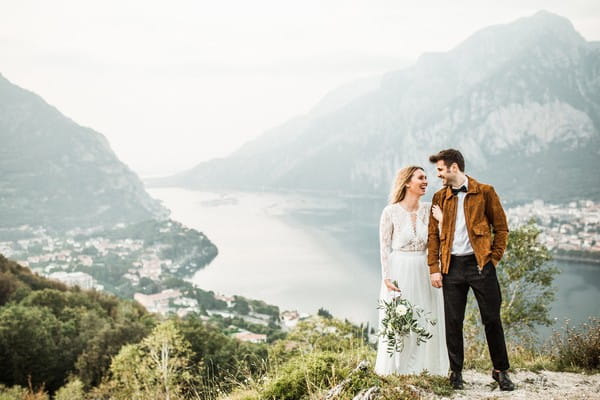 Bride and groom holding hands with Lake Como in background