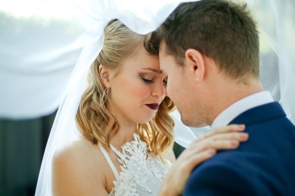 Bride and groom under bride's veil