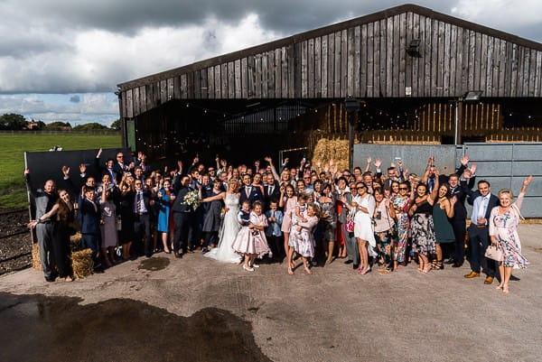 Wedding guests outside cow shed