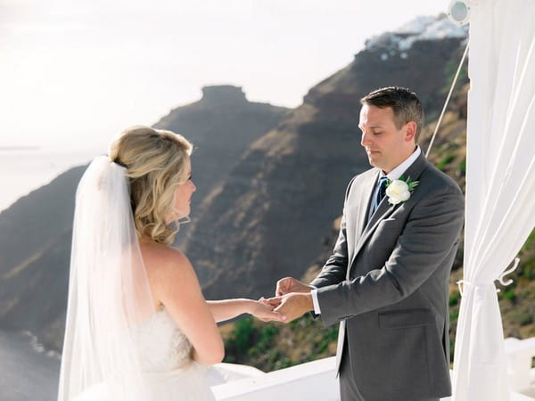 Groom putting ring on bride's finger