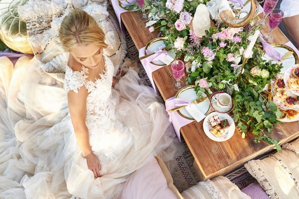 Bride sitting by outdoor wedding table