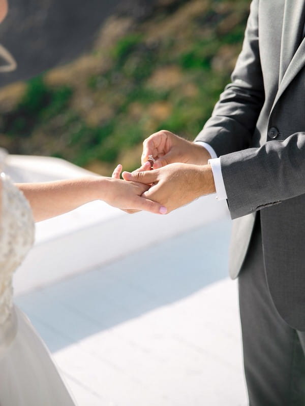 Groom putting ring on bride's finger