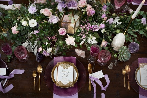 Purple wedding place setting with large floral centrepiece