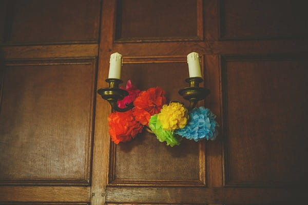 Colourful pom poms tie to candlesticks