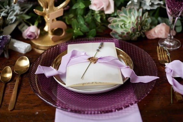 Wedding stationery with seal, ribbon and lavender on purple plate