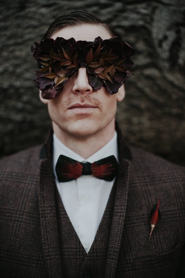 Groom with foliage mask over eyes