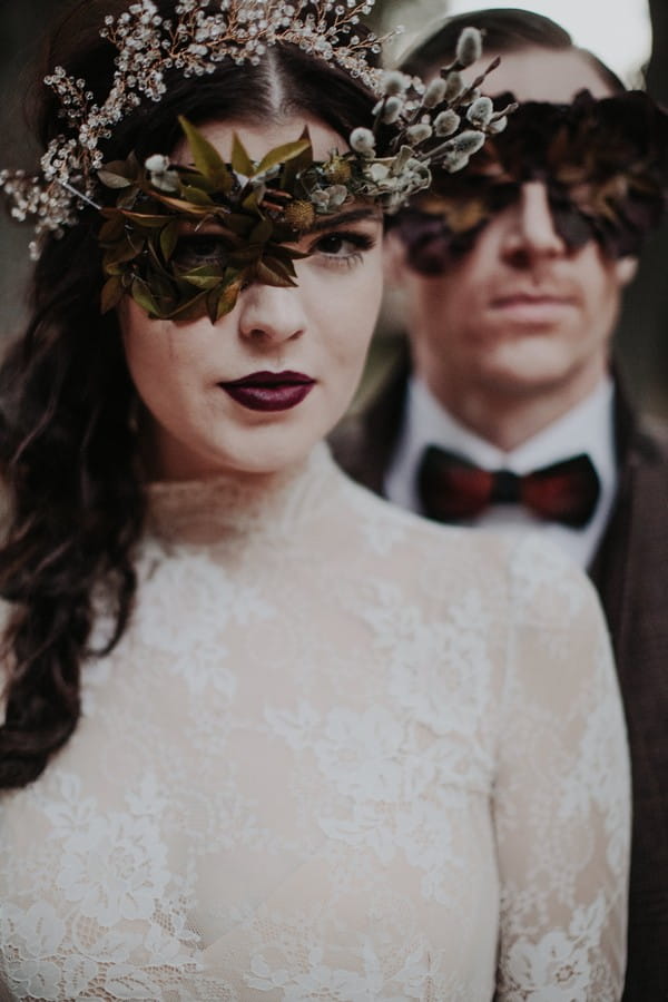 Bride and groom with foliage mask over eyes