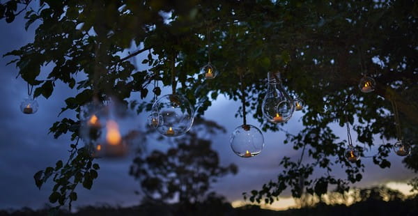 Glass baubles with tea lights hanging from tree