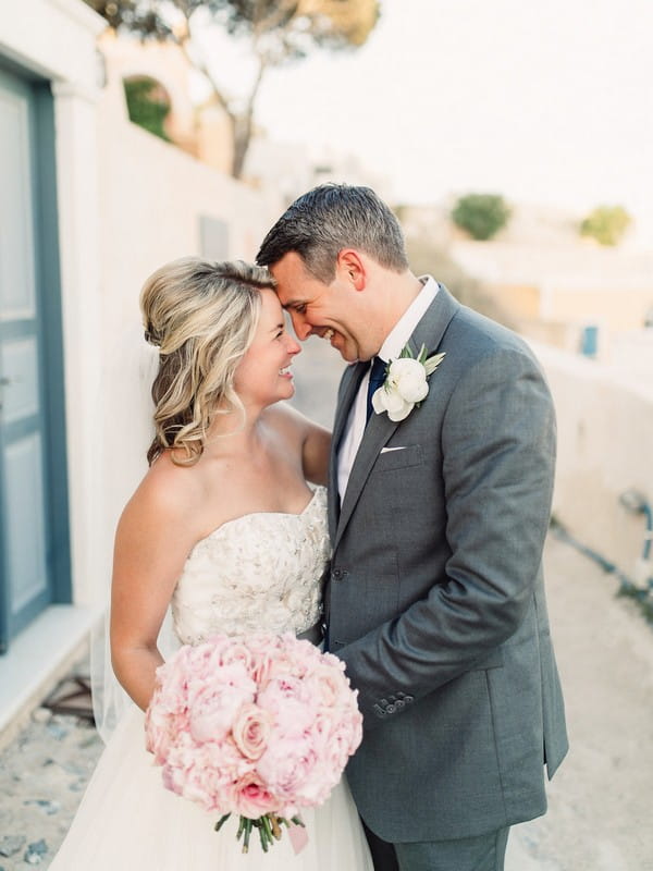 Bride and groom resting heads on each other