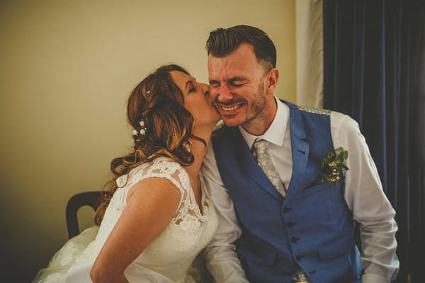 Bride kissing groom on cheek