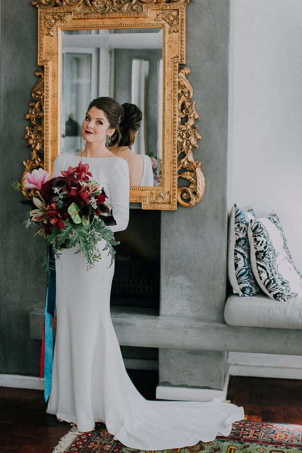 Bride holding bouquet in front of mirror