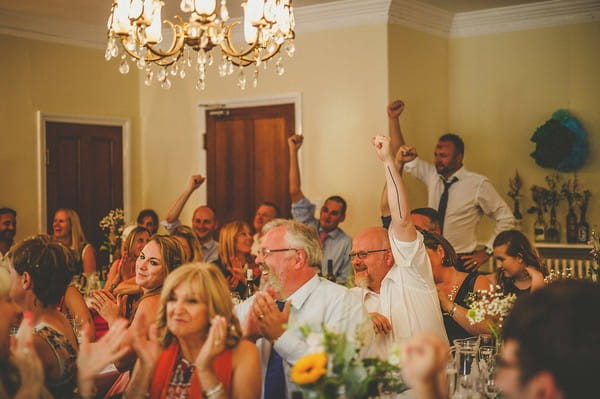 Wedding guests holding arms up