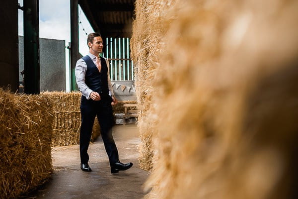 Groomsman walking into cow shed