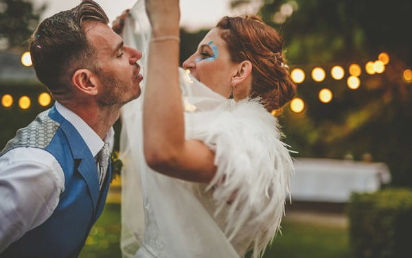 Groom about to kiss bride wearing feather shrug