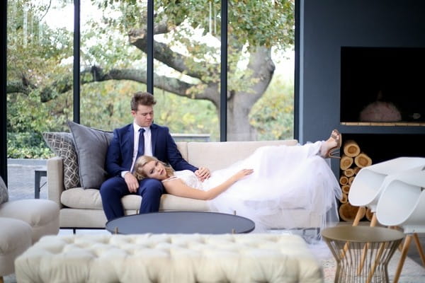 Bride laying on couch resting head on groom's lap