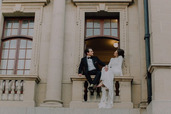 Bride and groom sitting on balcony of Centre for the Book