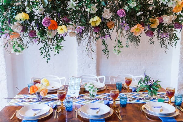 Urban tribal wedding table styling under hanging floral display