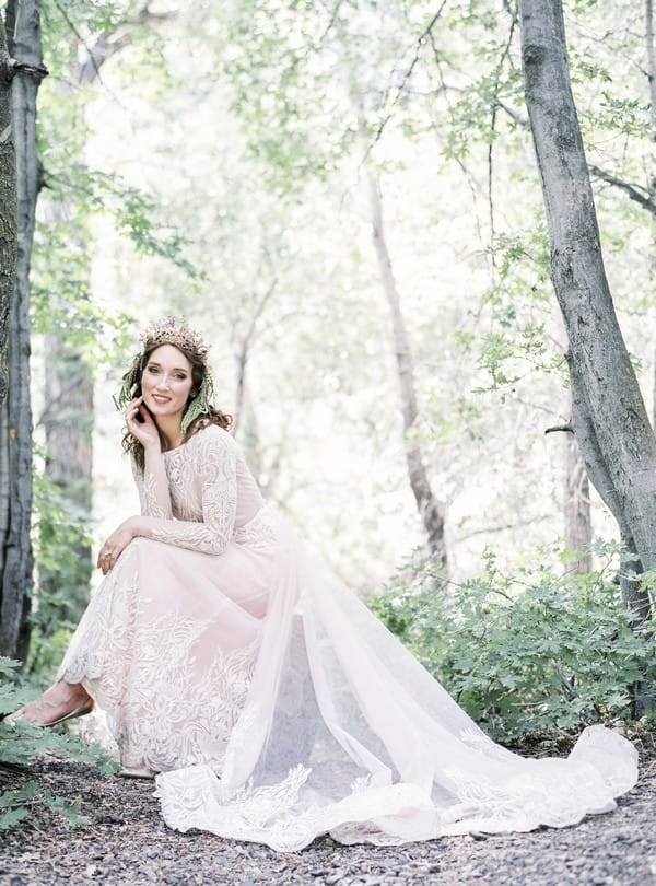 Bride sitting in woods