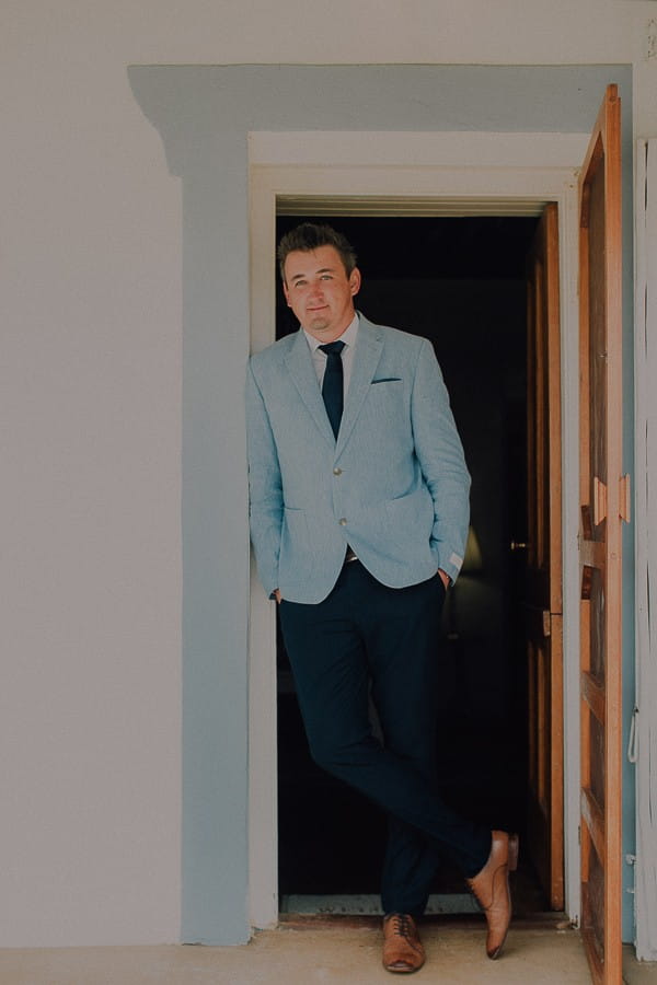 Groom leaning in doorway