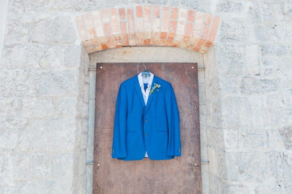 Blue Ted Baker suit jacket hanging on door