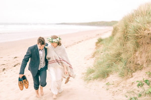 Bride and groom walking on beach - Picture by Matt Ethan Photography