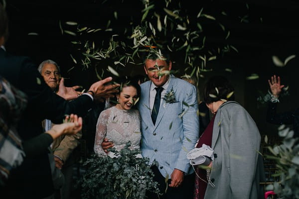 Bride and groom being showered in leaves